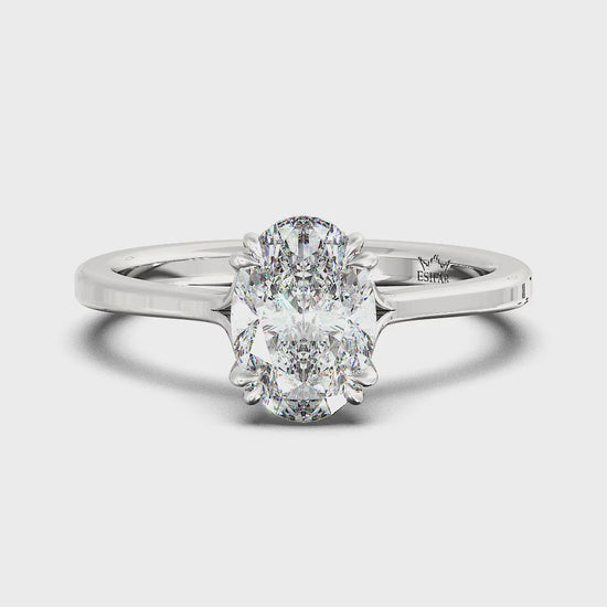 Golden oval solitaire diamond ring with twisted double prongs, symbolizing timeless love and romance.