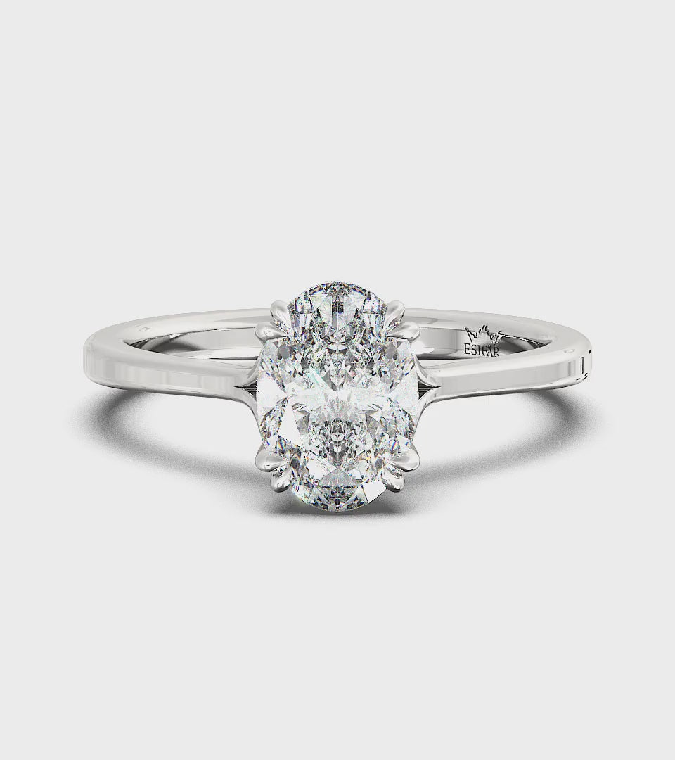Golden oval solitaire diamond ring with twisted double prongs, symbolizing timeless love and romance.